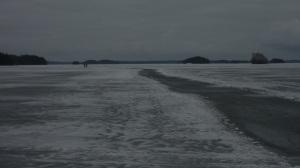 Jäinen hiljainen polku ja järvi talviunillaan